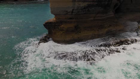 4k aerial big rock in the ocean near the coast drone truck right to left + tilt up shot