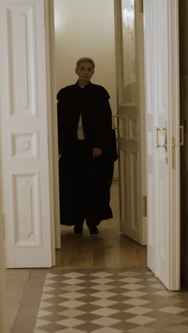 Elderly Priest/Judge Walking Through a Door