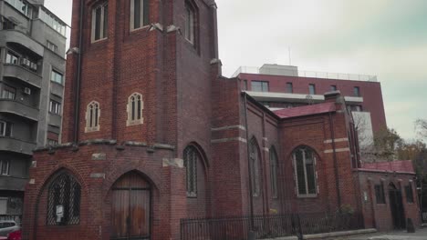 tilt-up shot of a red brick church in bucharest on an overcast day