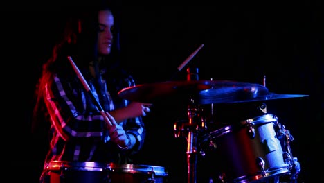 batería femenina tocando en un conjunto de tambores 4k