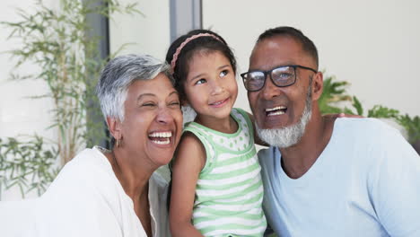 Ein-Biracial-Mädchen-Mit-Einem-Strahlenden-Lächeln-Wird-Von-Ihren-Fröhlichen-Großeltern-Flankiert