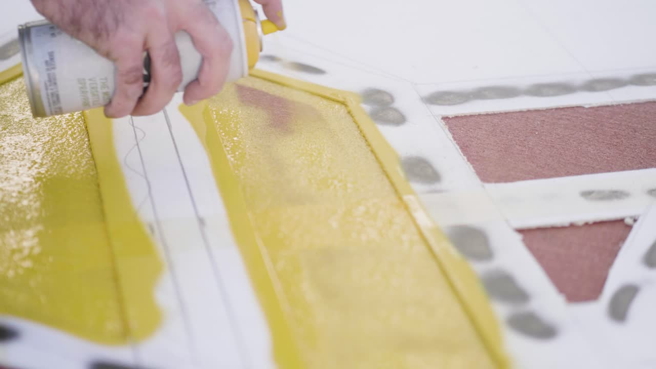 Spray paint can highlighting yellow color applied to an artistic surface for design work