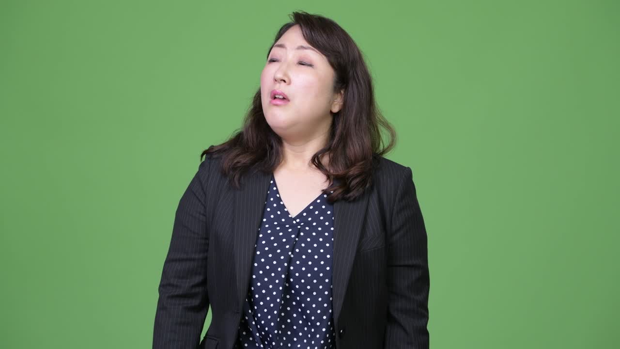 Mature beautiful Asian businesswoman looking bored