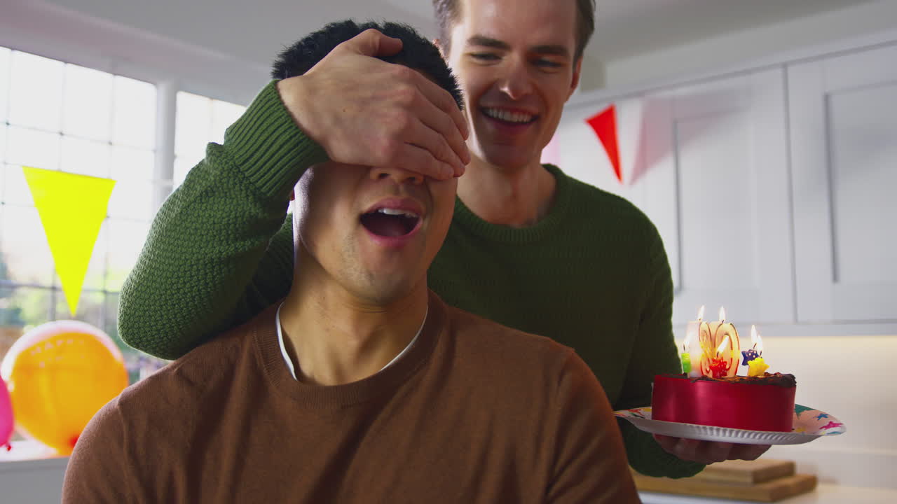 Same Sex Male Couple Celebrating 30th Birthday At Home With Cake And Presents