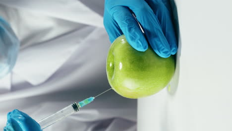 injecting a green apple