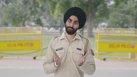 happy sikh indian police man doing namaste