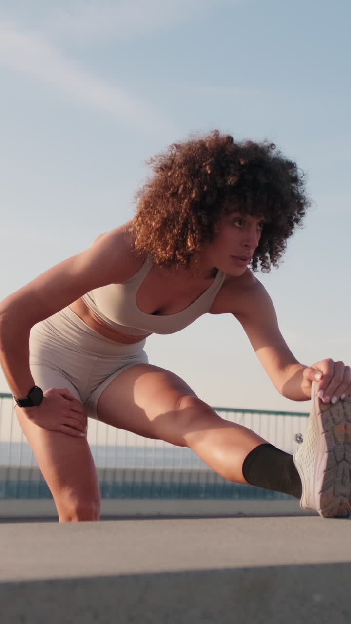 Young Woman Stretching next to the Sea