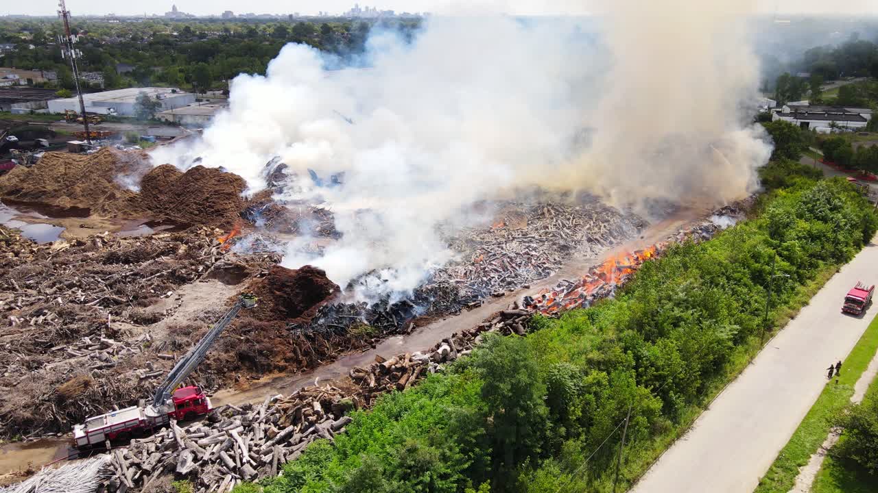 Mulch company on fire, fire engine bellow, aerial view