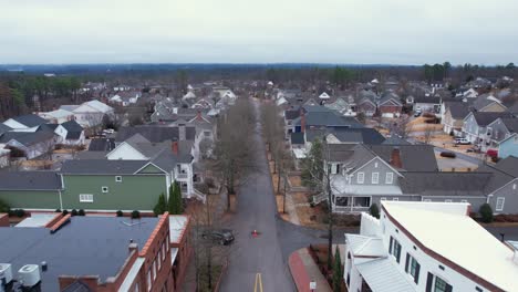 aerial pull away revealing small town shops and roundabout in front of sprawling suburban area at moss rock preserve in hoover, alabama