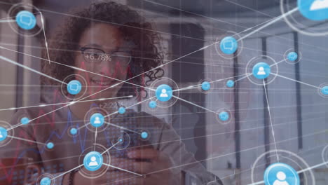 animación de iconos conectados con gráficos y números cambiantes, hombre biracial usando teléfono celular