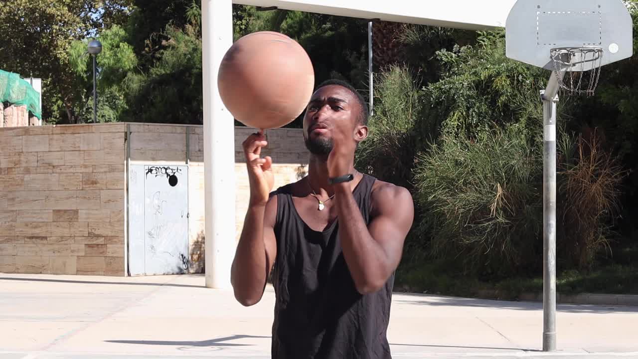 hombre negro girando el baloncesto en el dedo