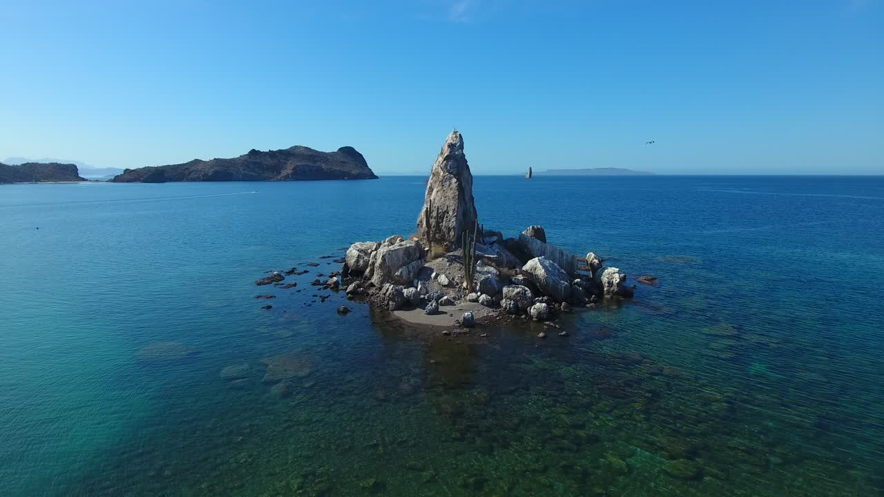 Hovering Aerial of Small Rock Island and Birds Flying Around It with Background Islands