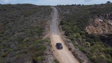 car driving on a scenic dirt road through australian bush