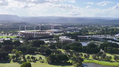 high-definition aerial view showcasing a golf course, river, and urban buildings under a bright sky.