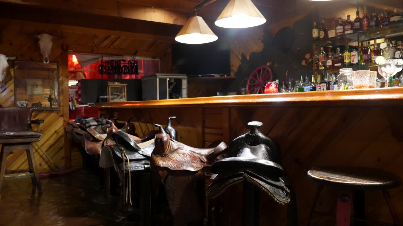 Interno di un bar rustico in stile western con selle come sgabelli da bar