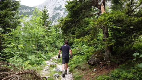 一名穿着黑色衬衫的徒步旅行者走在德国阿尔卑斯山的步道上,