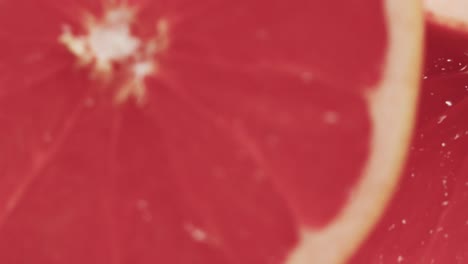micro video of close up of slices of red grapefruit with copy space