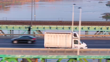 white truck driving on bridge over river