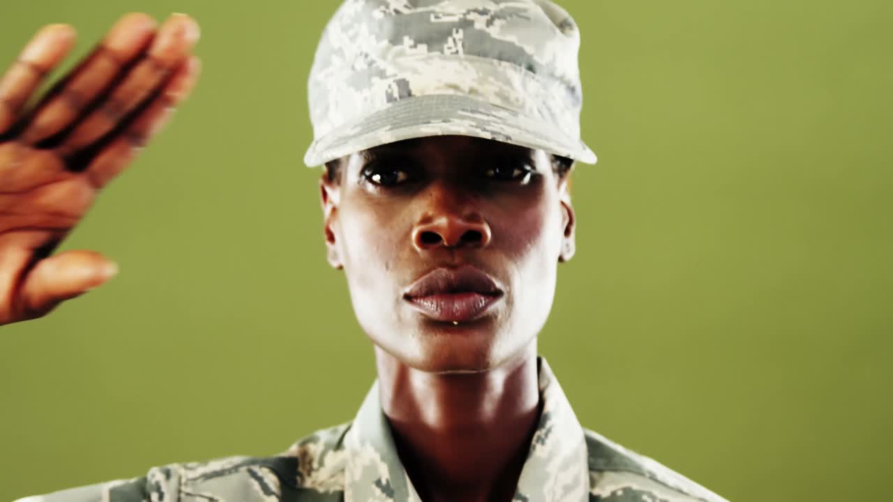homem andrógino em uniforme de camuflagem contra fundo verde