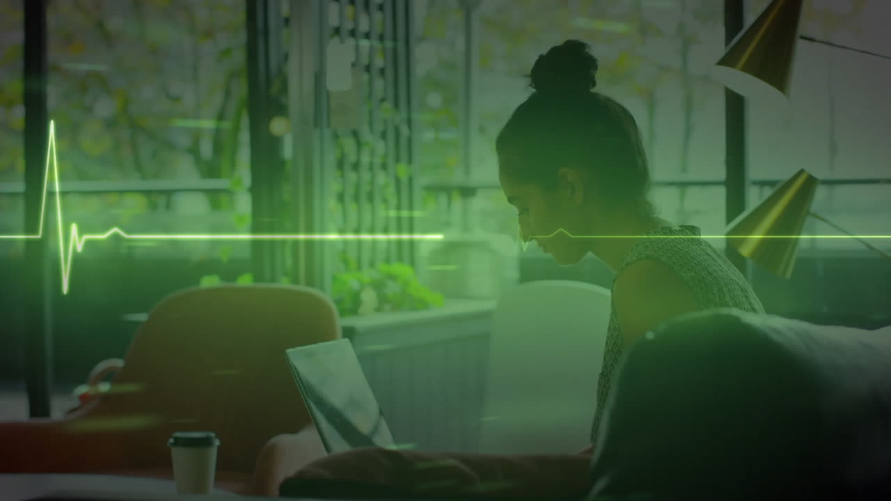 animación de una línea isoeléctrica sobre una mujer de negocios biracial que usa una computadora portátil en la oficina