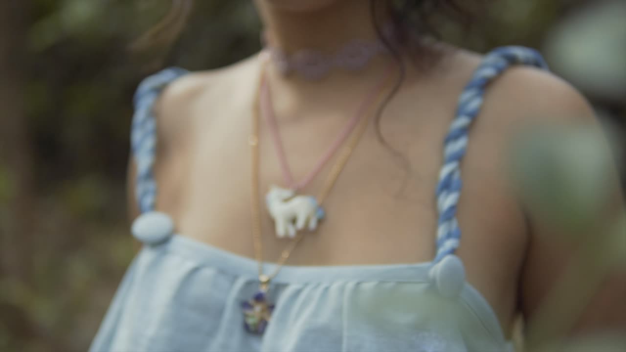 Unicorn and floral necklace around a young woman's neck