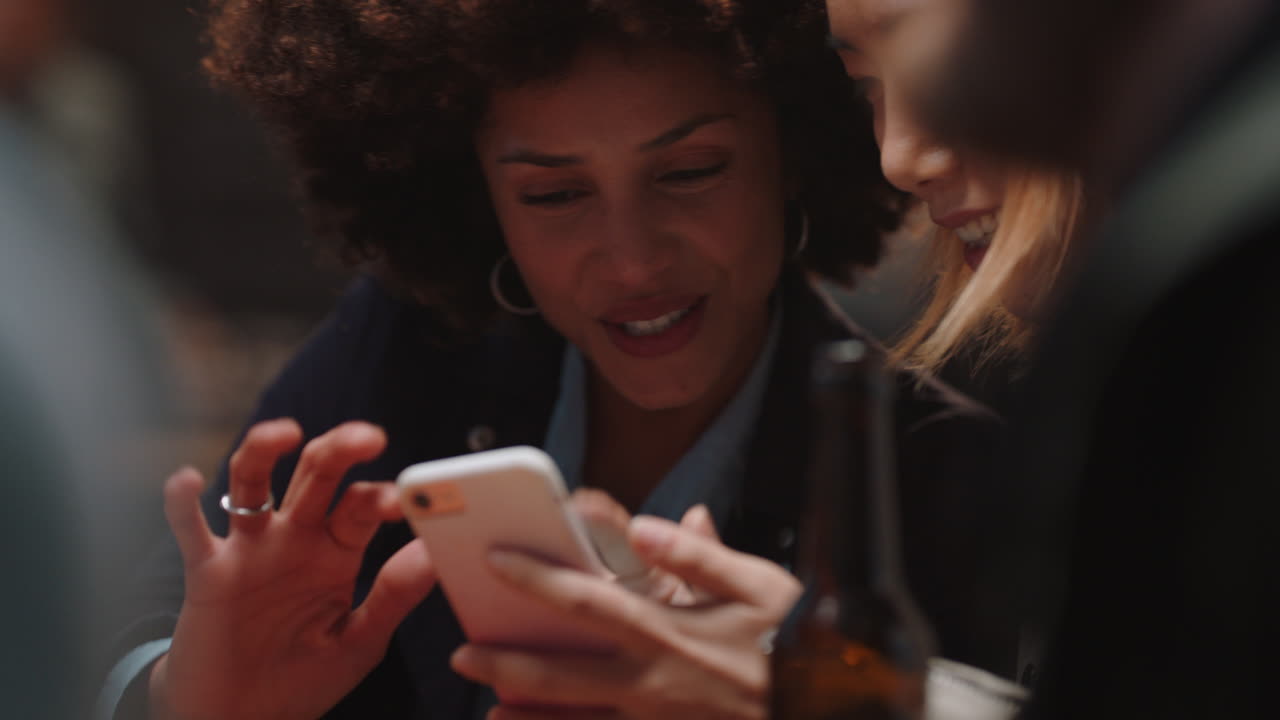 happy girl friends using smartphone in restaurant browsing social media sharing reunion party enjoying friendship chatting having fun socialzing together