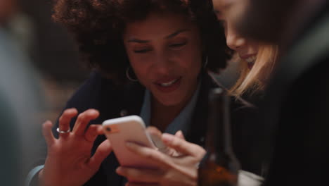 happy girl friends using smartphone in restaurant browsing social media sharing reunion party enjoying friendship chatting having fun socialzing together