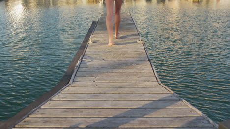 Rear-view-low-section-of-a-teenage-Caucasian-girl-walking-harbor-side