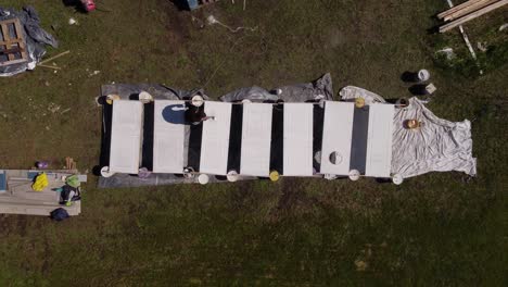 aerial footage of a man painting flat doors white