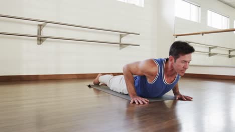 Hombre-Caucásico-Enfocado-Practicando-Yoga-En-El-Gimnasio,-Cámara-Lenta