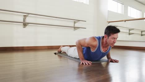 hombre caucásico enfocado practicando yoga en el gimnasio, cámara lenta
