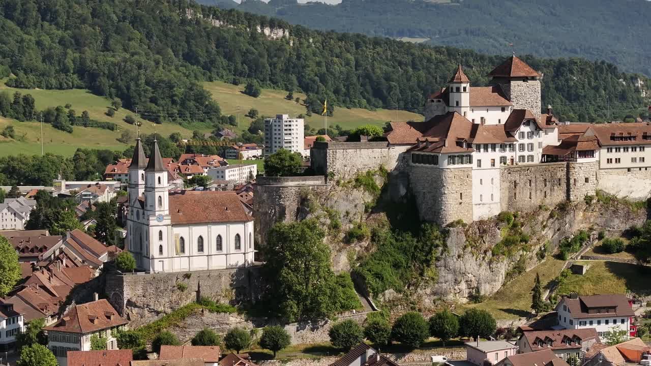 Aerial view of Aarburg’s medieval castle and church perched above the Aare River, surrounded by quaint rooftops and lush Swiss countryside in the canton of Solothurn
