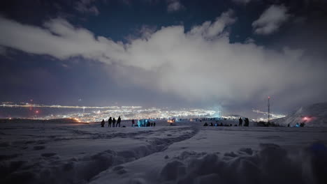 people in snow enjoy scenic vantage point over tromso