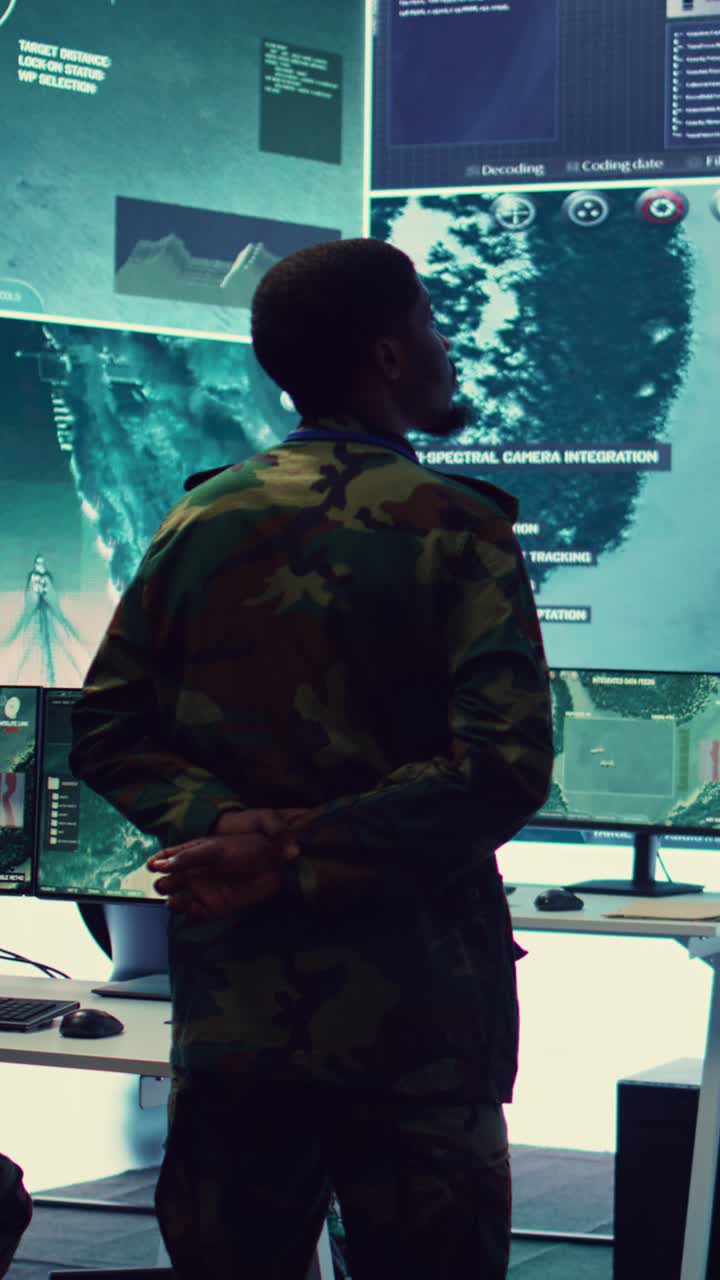 Man in Camouflage Uniform Monitoring Data on Multiple Screens