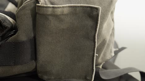 Hand-opens-side-compartment-of-shoulder-bag-with-velcro,-close-up