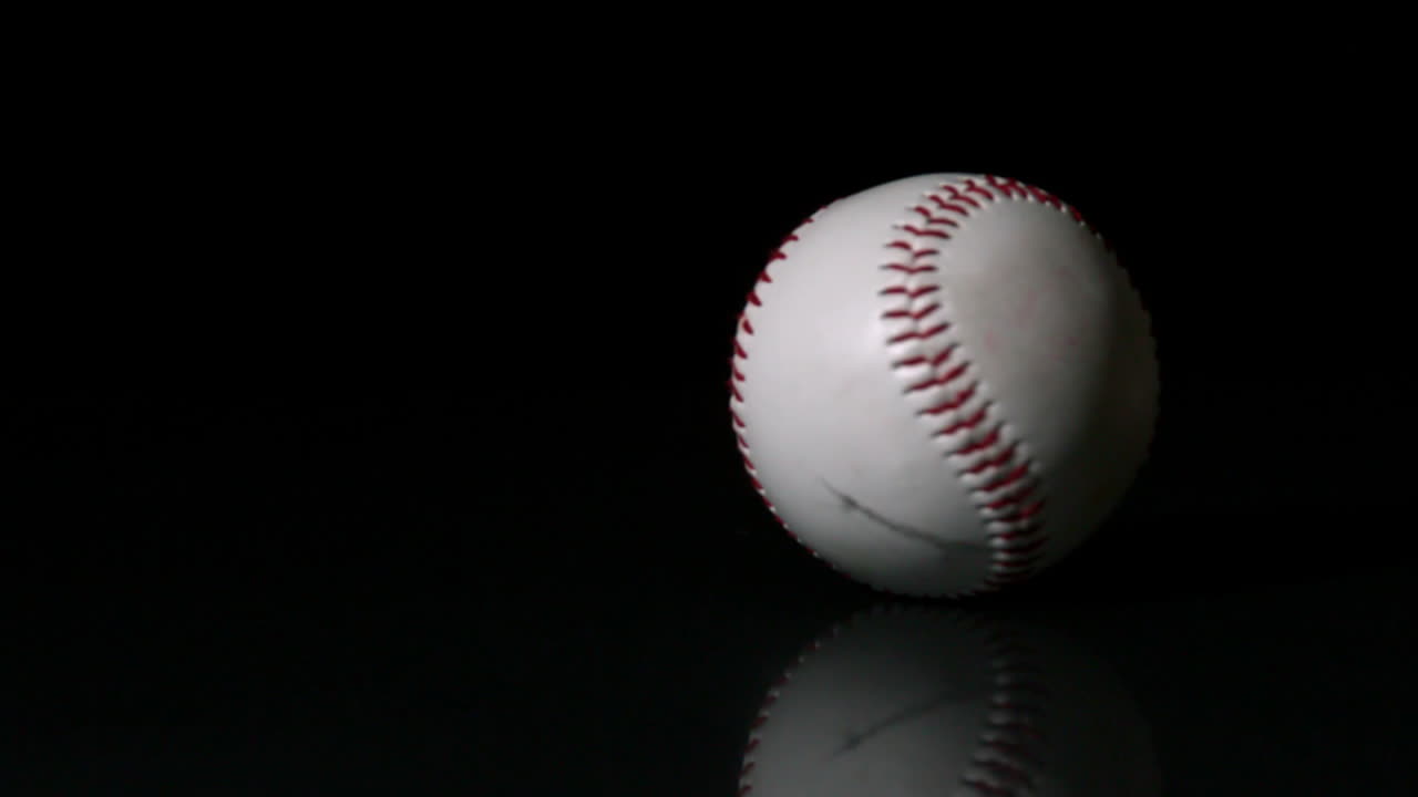 Palla da baseball che gira su superficie nera