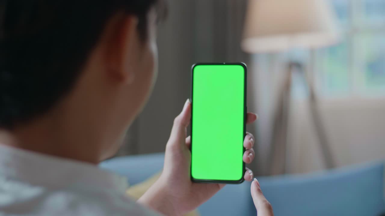 Close Up Of A Man Waving Hand And Talking To Green Screen Smartphone In The Living Room