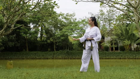 una mujer joven practicando taekwondo.