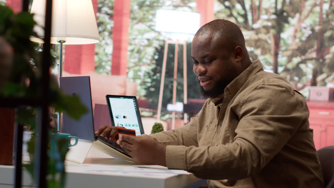 Business owner makes a payment with his card for online shopping at his home