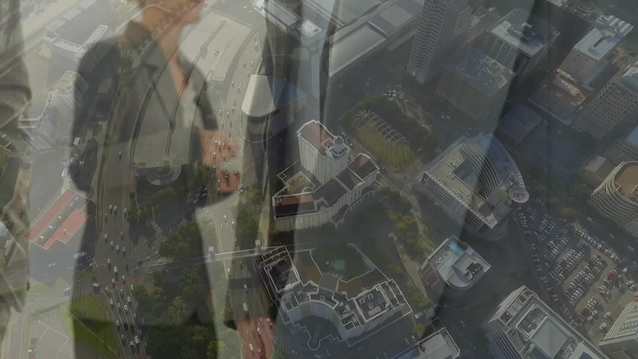 도시 풍경의 공중 전망에 맞서 손을 흔드는 사업가들의 중간 섹션의 디지털 구성