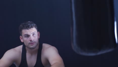 Determined-and-focused-male-boxer-boxing-in-dark-field.