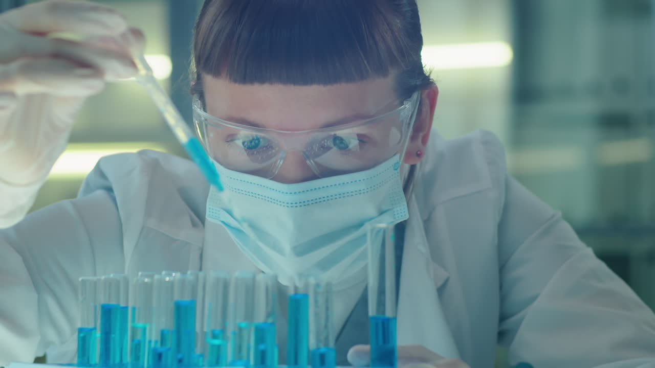 Female Chemist Pouring Blue Liquid in Test Tubes