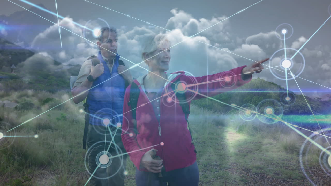 Female hiker pointing and male hiker adjusting backpack on trail, displaying tech network overlay
