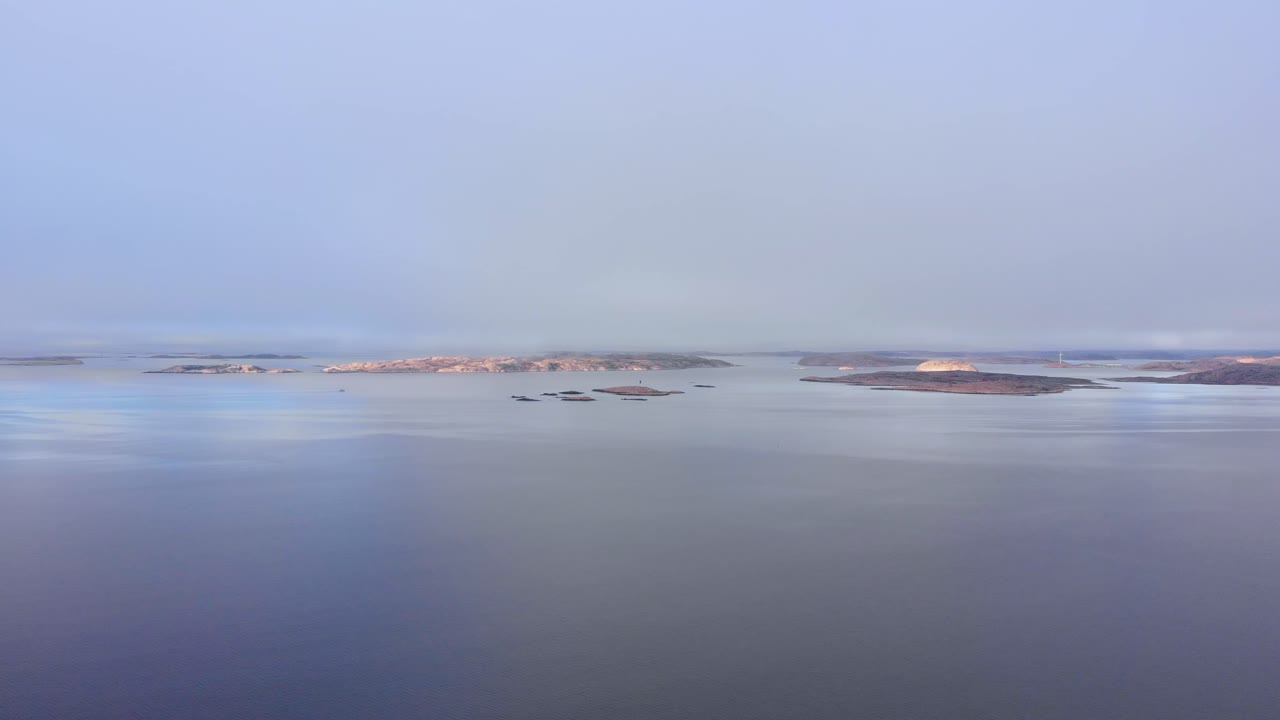 스웨덴의 리세킬의 평화롭고 조용한 물 위를 날아다니며 지평선과 멀리 작은 섬들과 함께 - 공중 촬영
