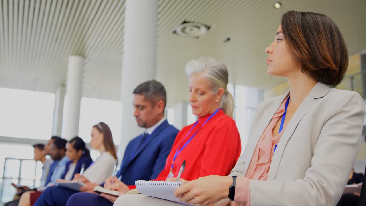 gente de negocios escribiendo en el bloc de notas en el seminario de negocios 4k