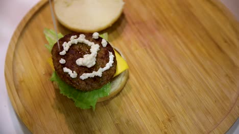 Mujer-De-Piel-Morena-En-Cámara-Lenta-Con-Esmalte-De-Uñas-Rojo-Está-Exprimiendo-Mayonesa-En-Carne-De-Hamburguesa