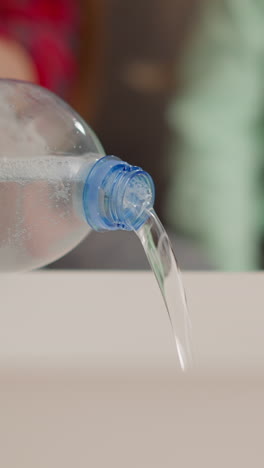 woman pours soapy water into tray from bottle with little girl sitting on sofa extreme closeup. material for art craft. hobby and leisure at home