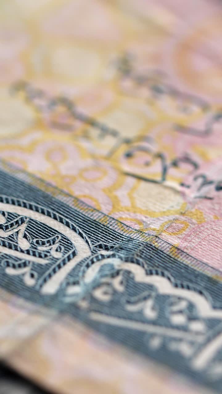 Vertical macro shot of different international banknotes dropping in sequence, each with shifting zoom