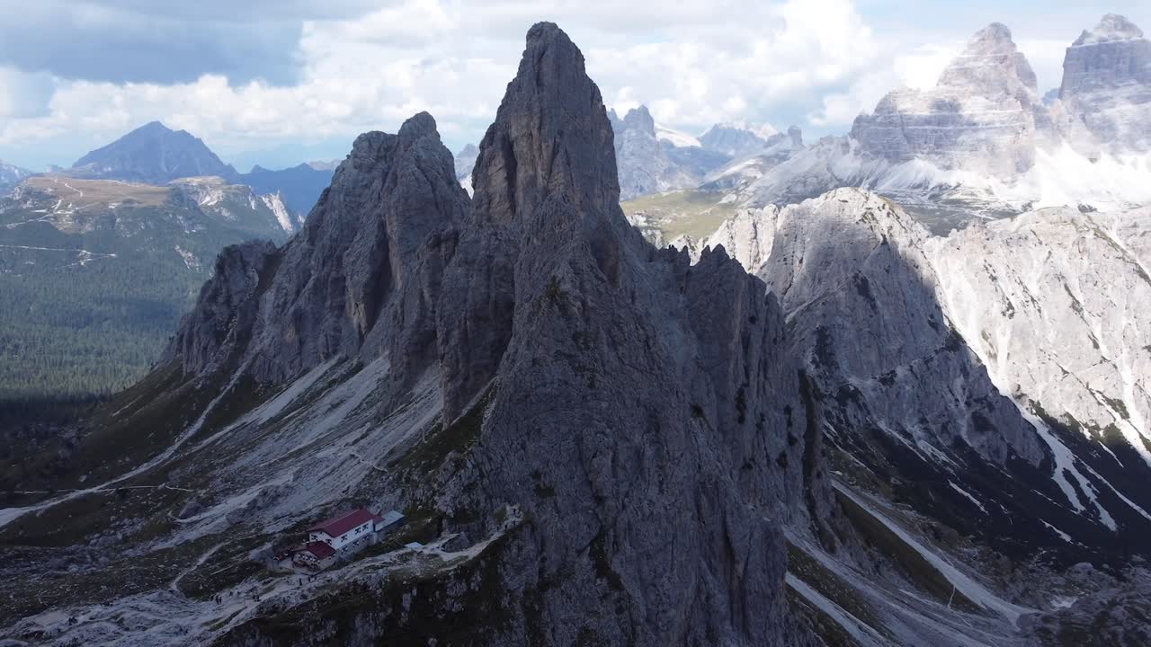 una impresionante toma de drones de una casa solitaria ubicada en medio de las montañas y formaciones rocosas de los dolomitas en el tirol del sur en italia