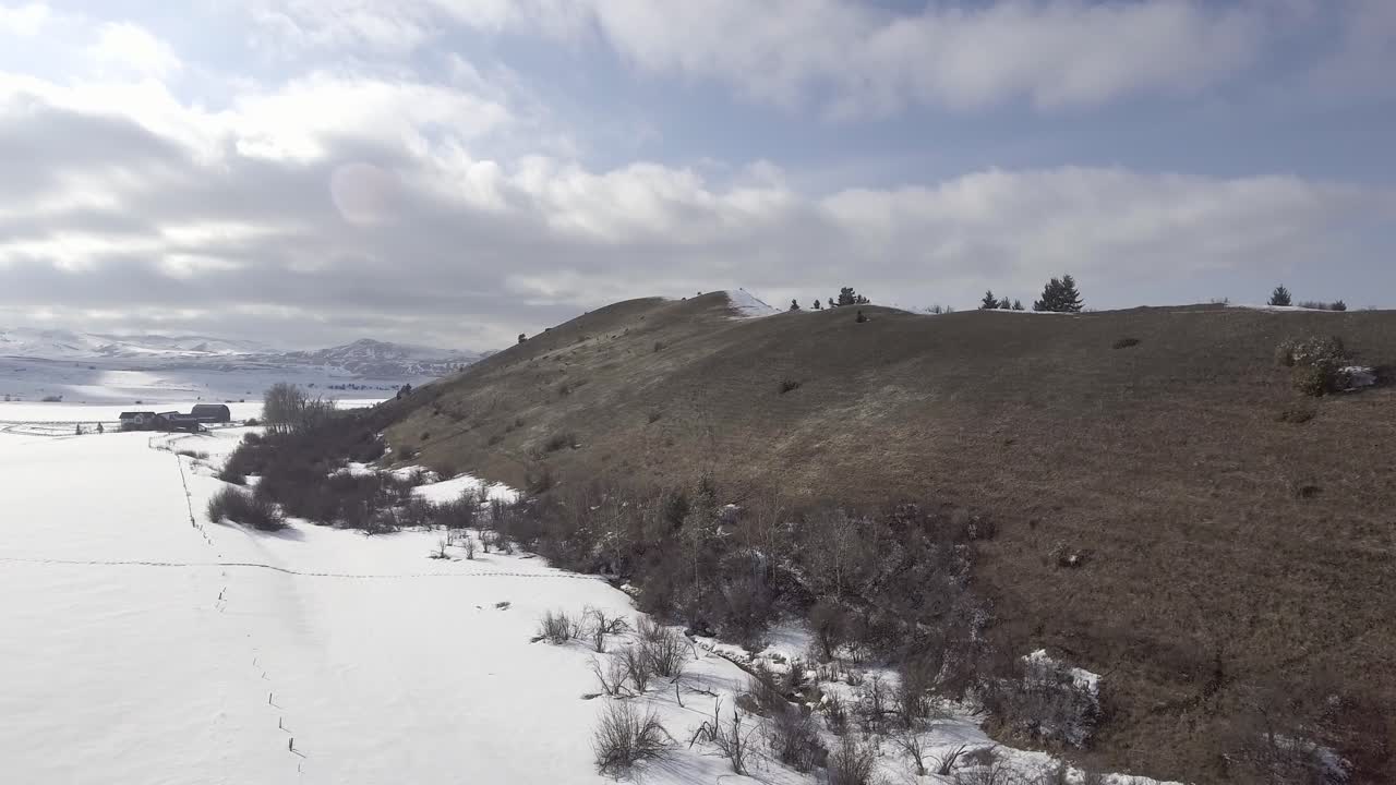 dolly zoom de la montaña junto al campo nevado con nubes tormentosas que se avecinan